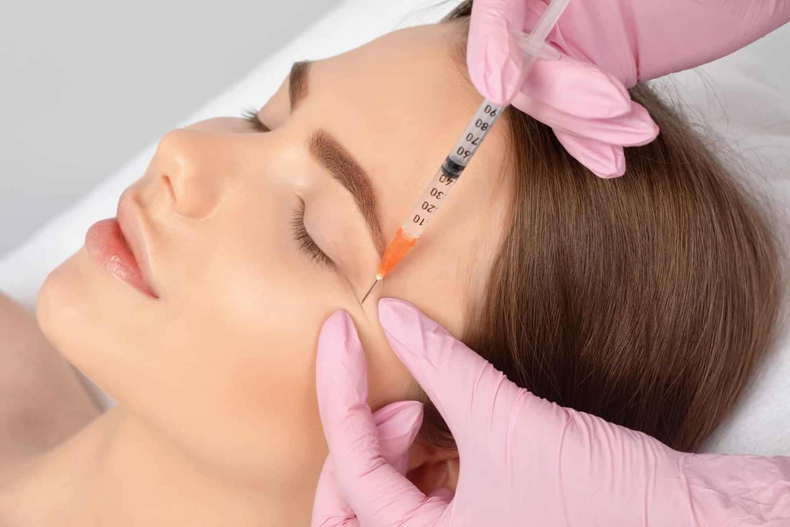 Beautiful woman using botox injector for her wrinkles